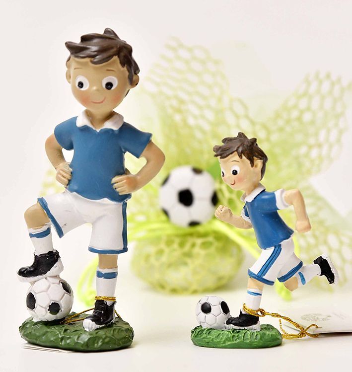 Due statuette di calciatori, una con il piede sulla palla, l'altra che corre. Magliette blu, pantaloncini bianchi, base verde.
