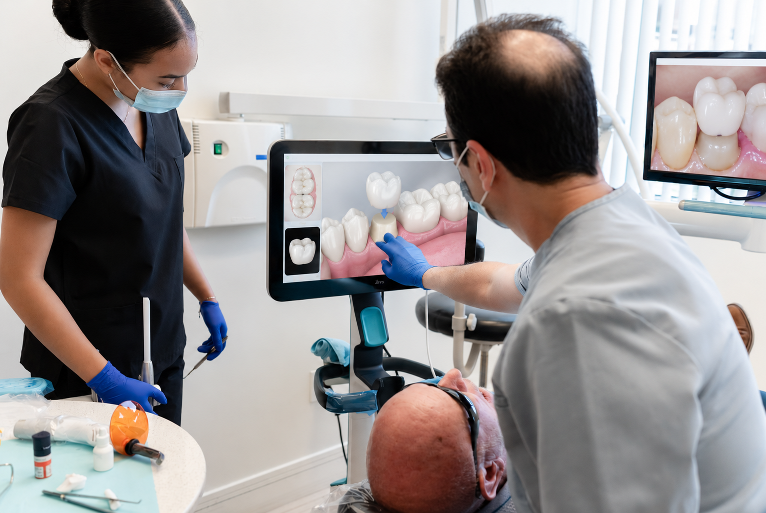 Dental team reviewing patient’s teeth on a monitor in a clinic