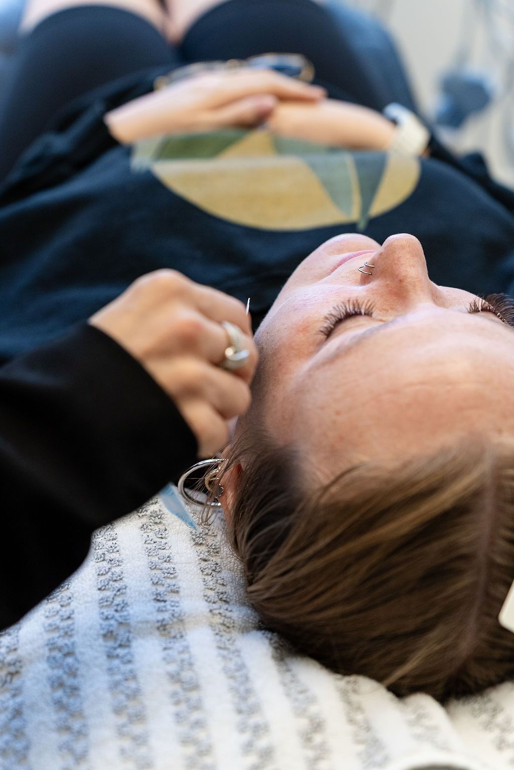 Patient reclines in a dental chair while a dentist works above them with a circular mirror-like tool.