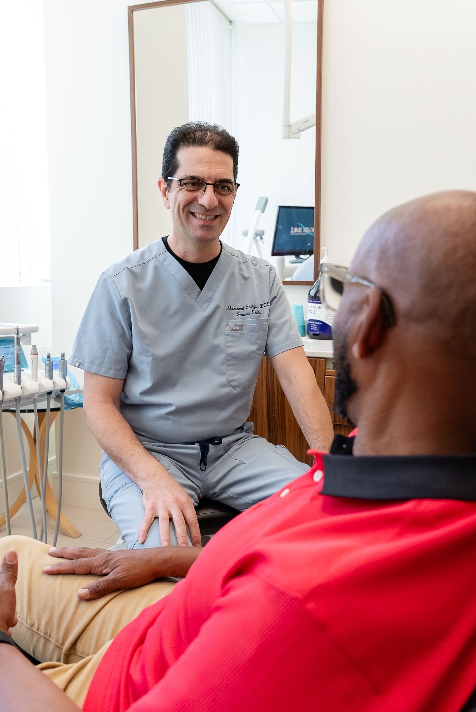 Doctor talking with a seated patient in a clinic office
