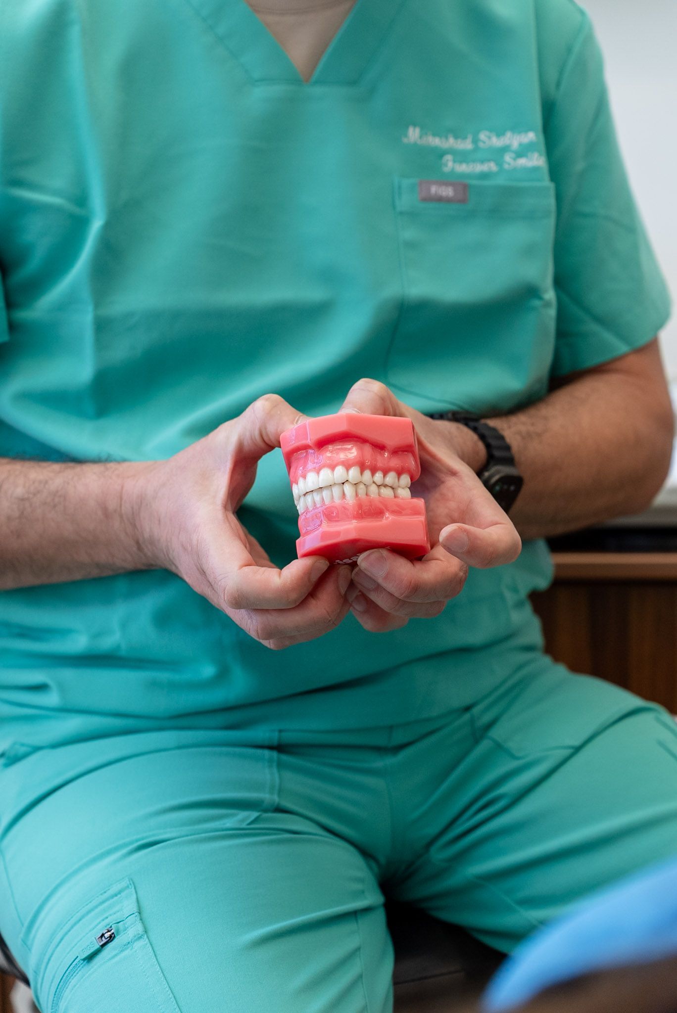 Dr. Shelyan explaining restorative dental treatment with a teeth model