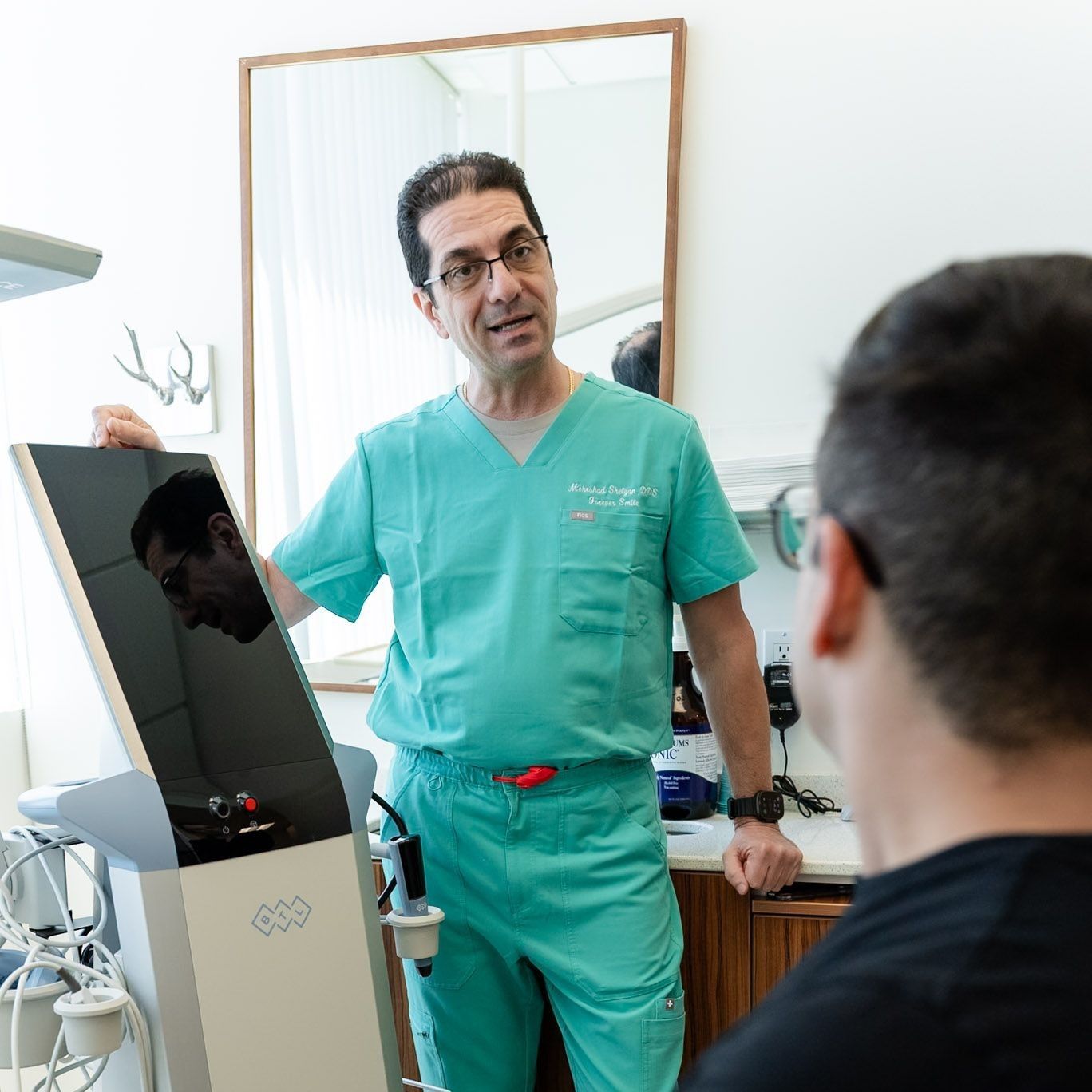 Dr. Shelyan explaining EMFACE TMJ treatment at a Los Angeles dental office