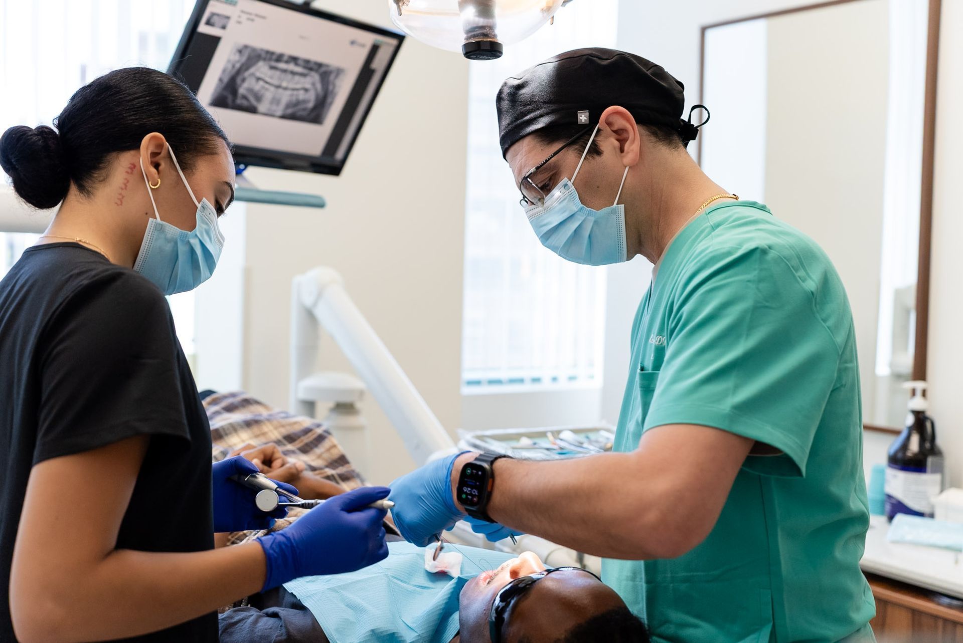 Dentist and assistant treating a patient's gums at Forever Smile