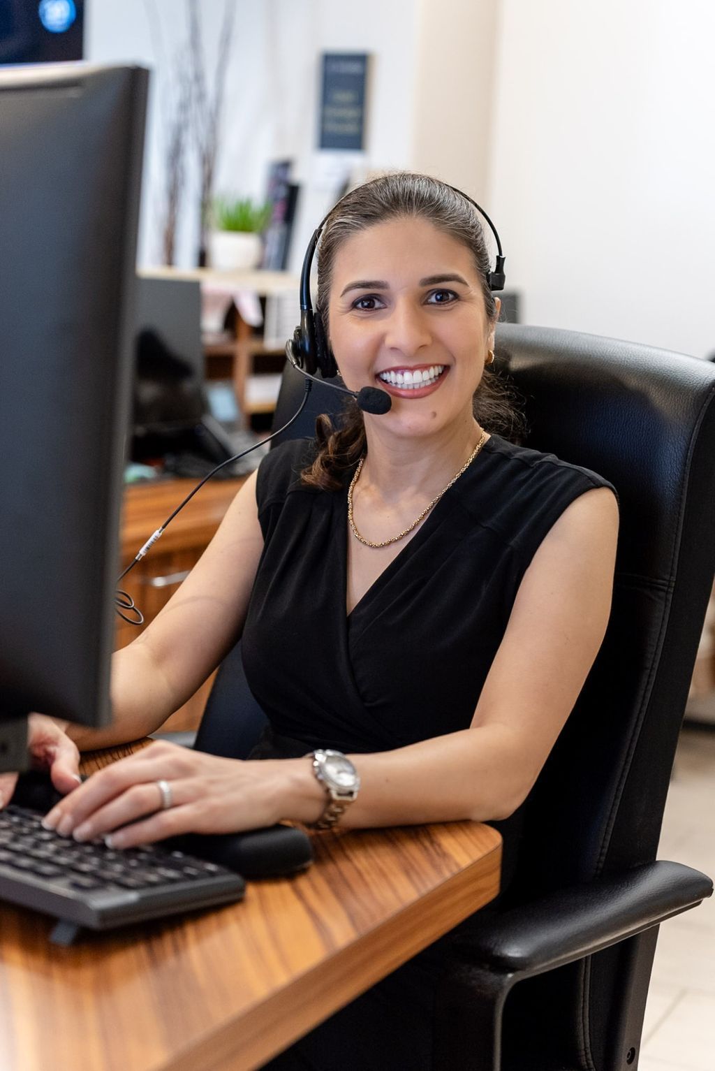 Sarit, practice manager, smiling at the Forever Smile front desk in Los Angeles