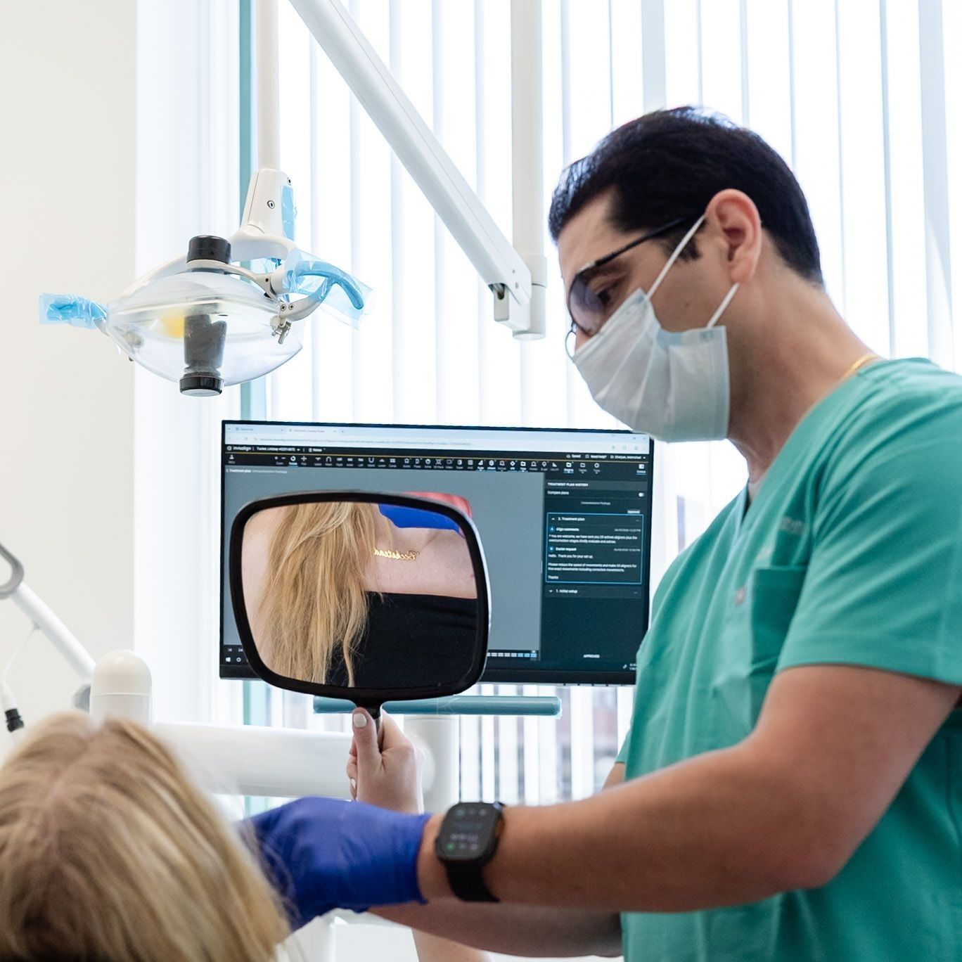 A patient checking her smile in the mirror at a Los Angeles dental office