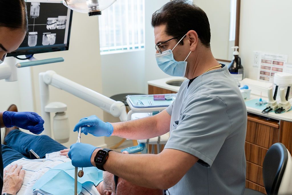 Dentist in blue gloves and mask working on a patient in a dental clinic
