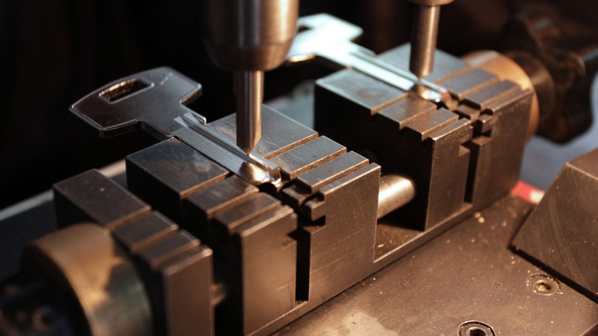A machine is cutting a key into a piece of metal.