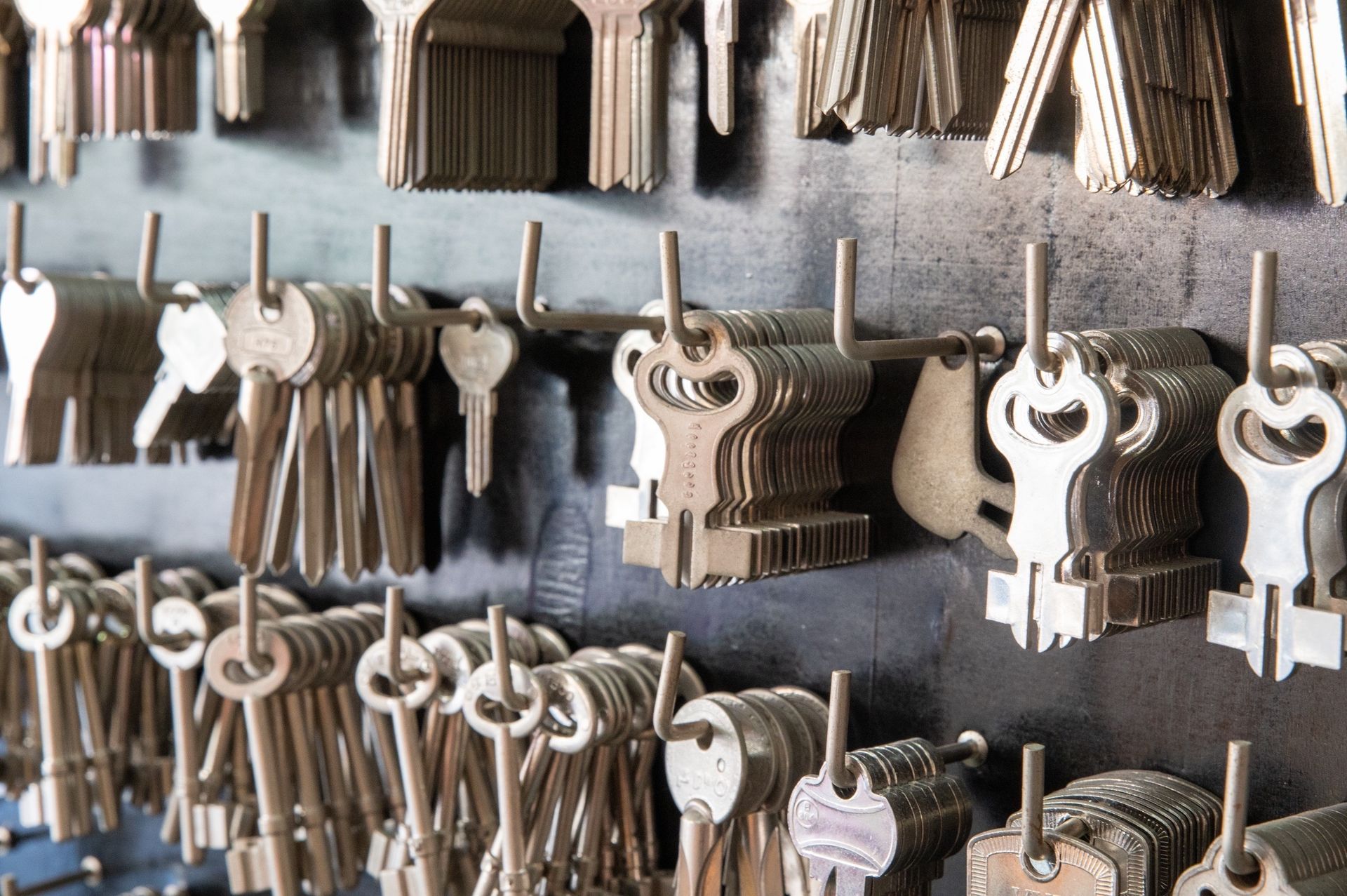 A bunch of keys are hanging on a wall