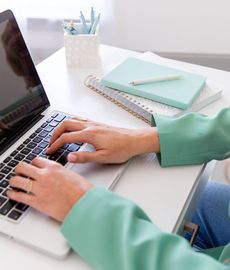 a person is typing on a macbook pro laptop