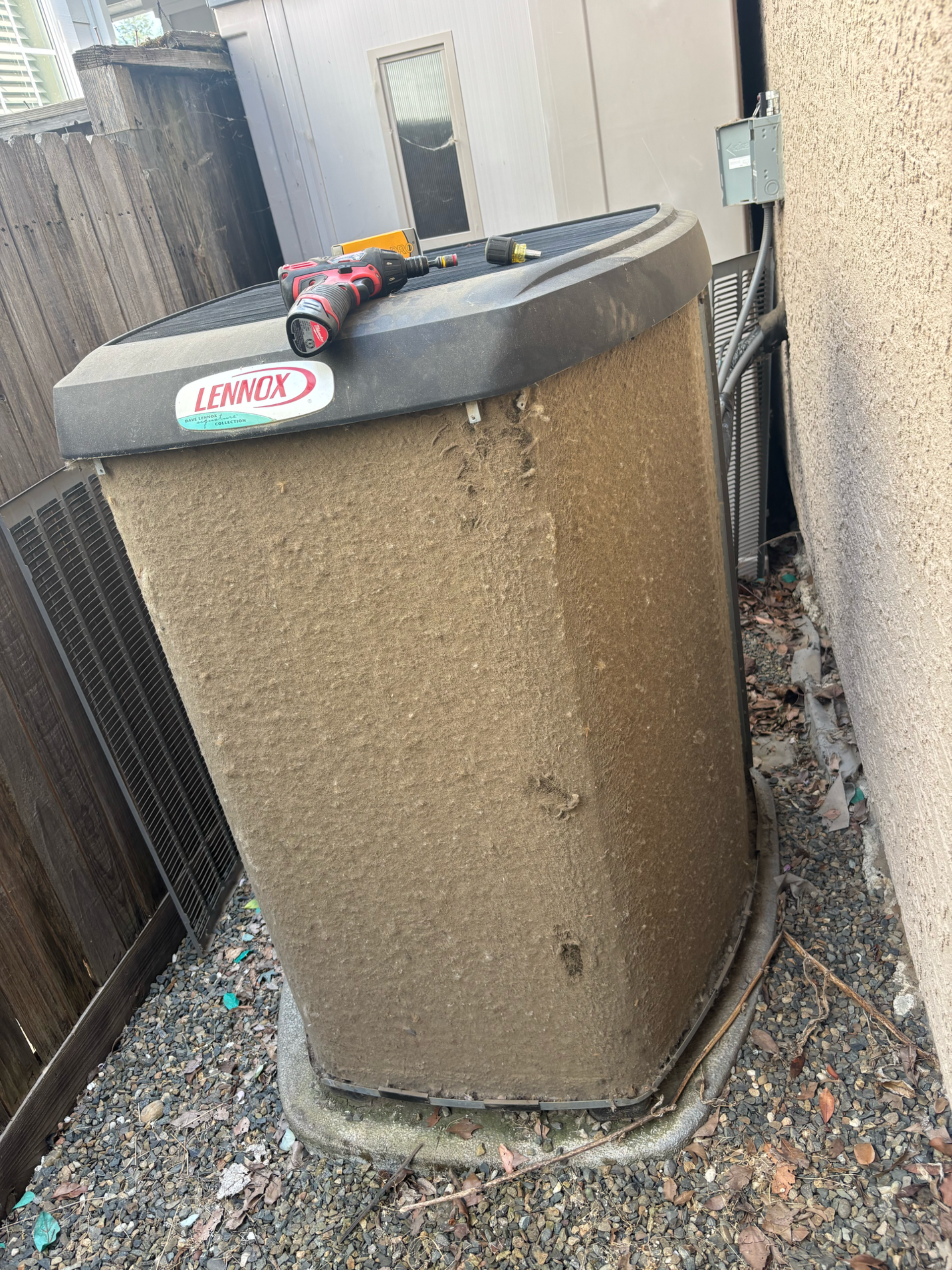 Trash bin next to a garage door, showing dirt and debris. A