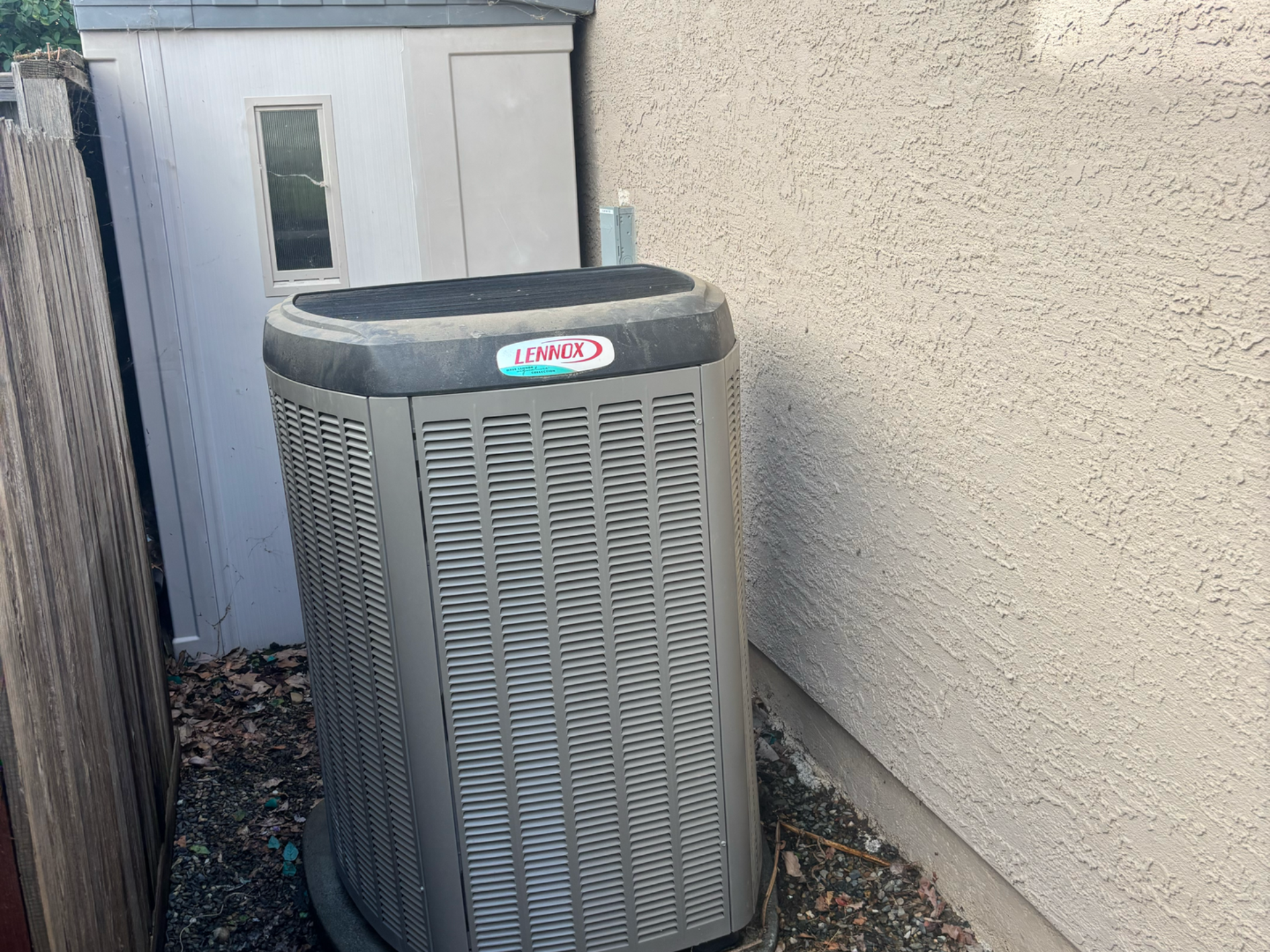 Air conditioning units with toolbox and gloves in backyard.