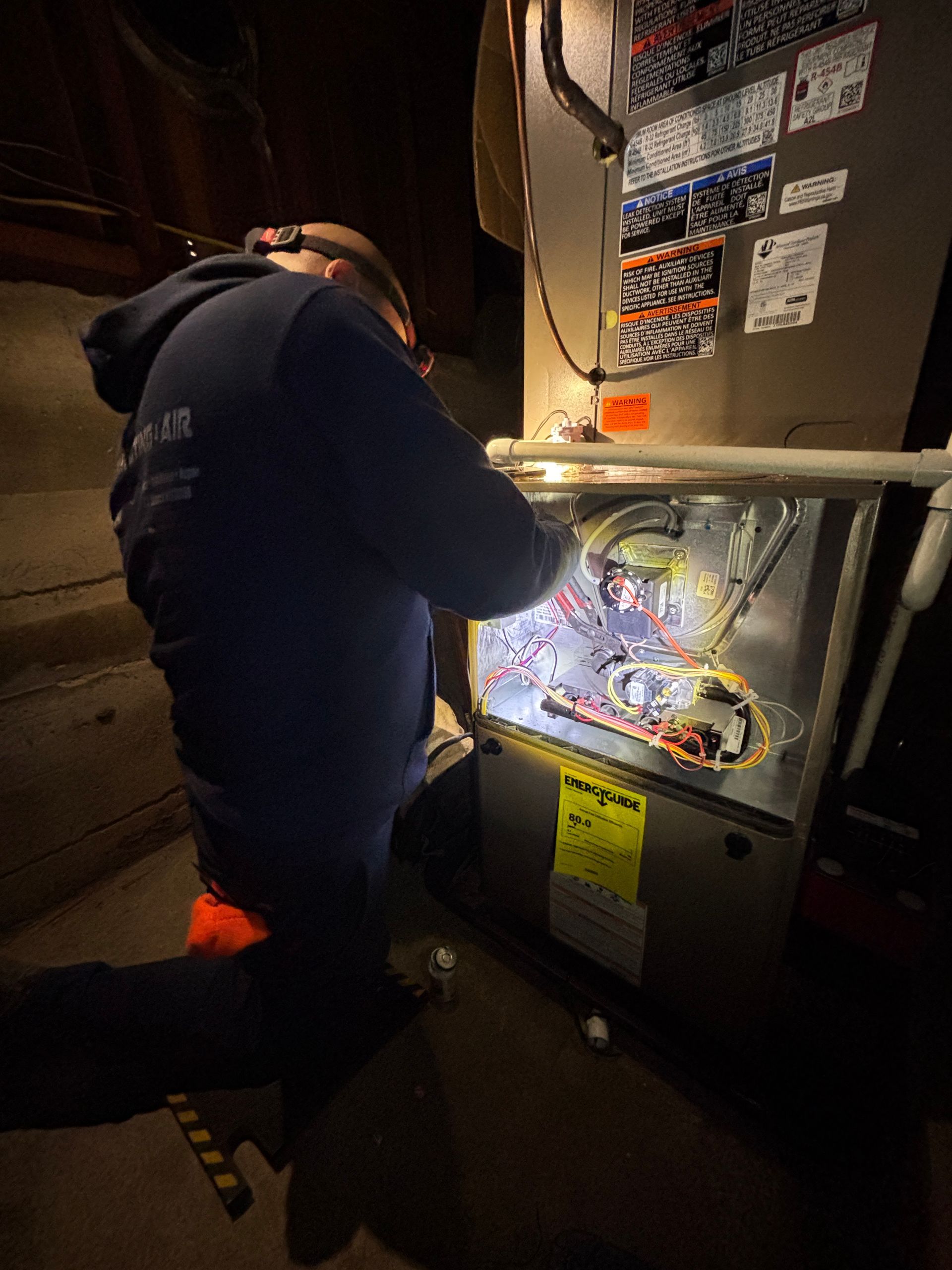 Air conditioning units with toolbox and gloves in backyard.
