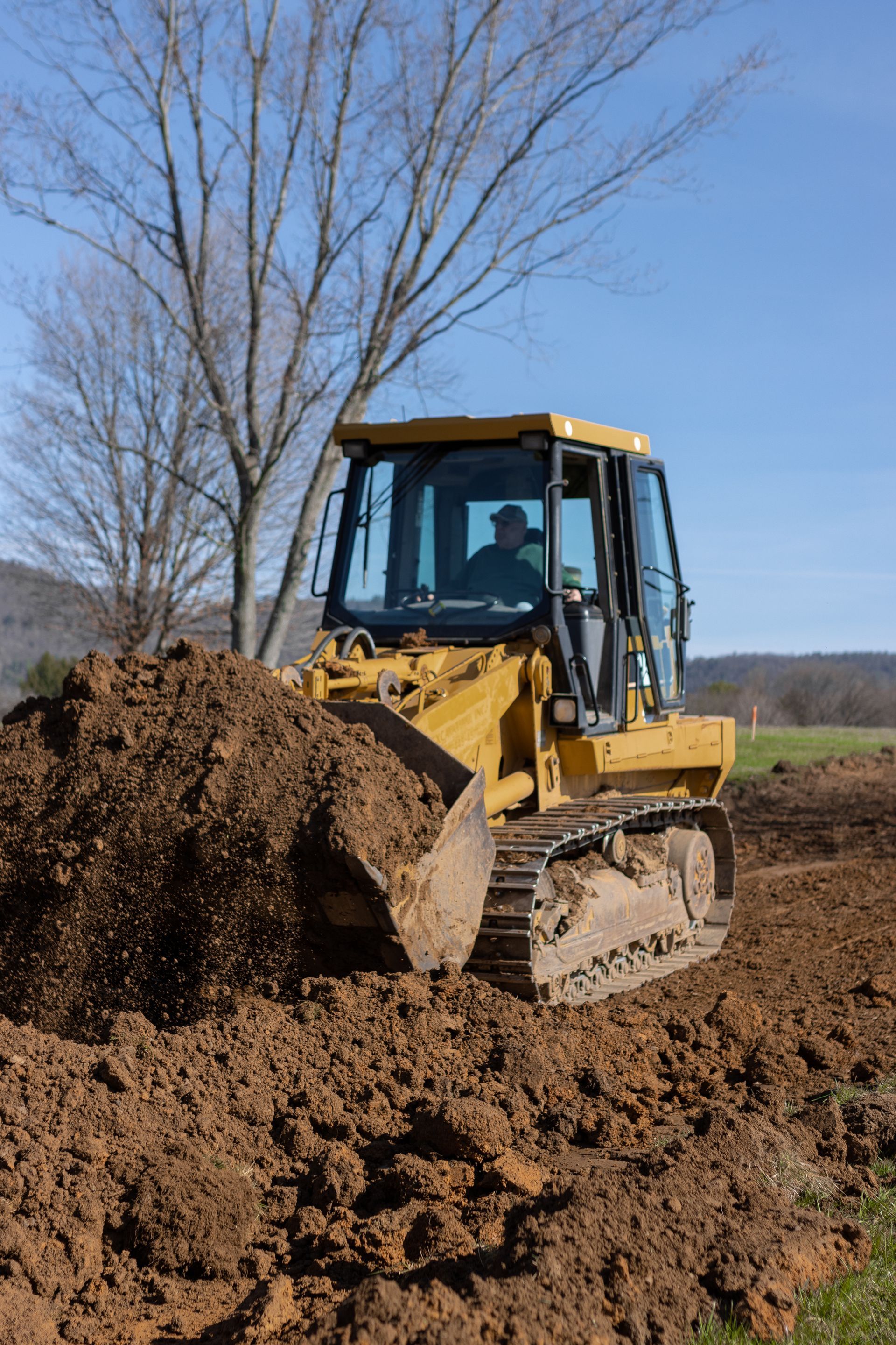 A bulldozer is moving dirt in a field.