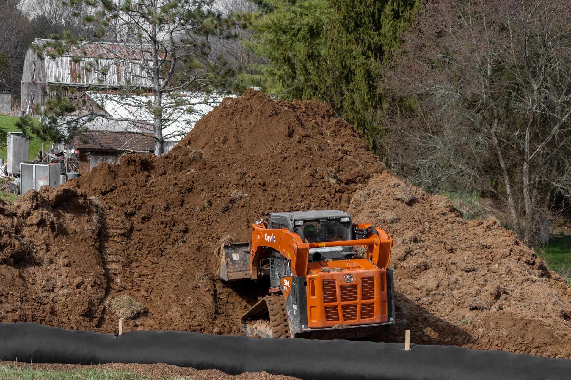 A large pile of dirt is being moved by a bulldozer