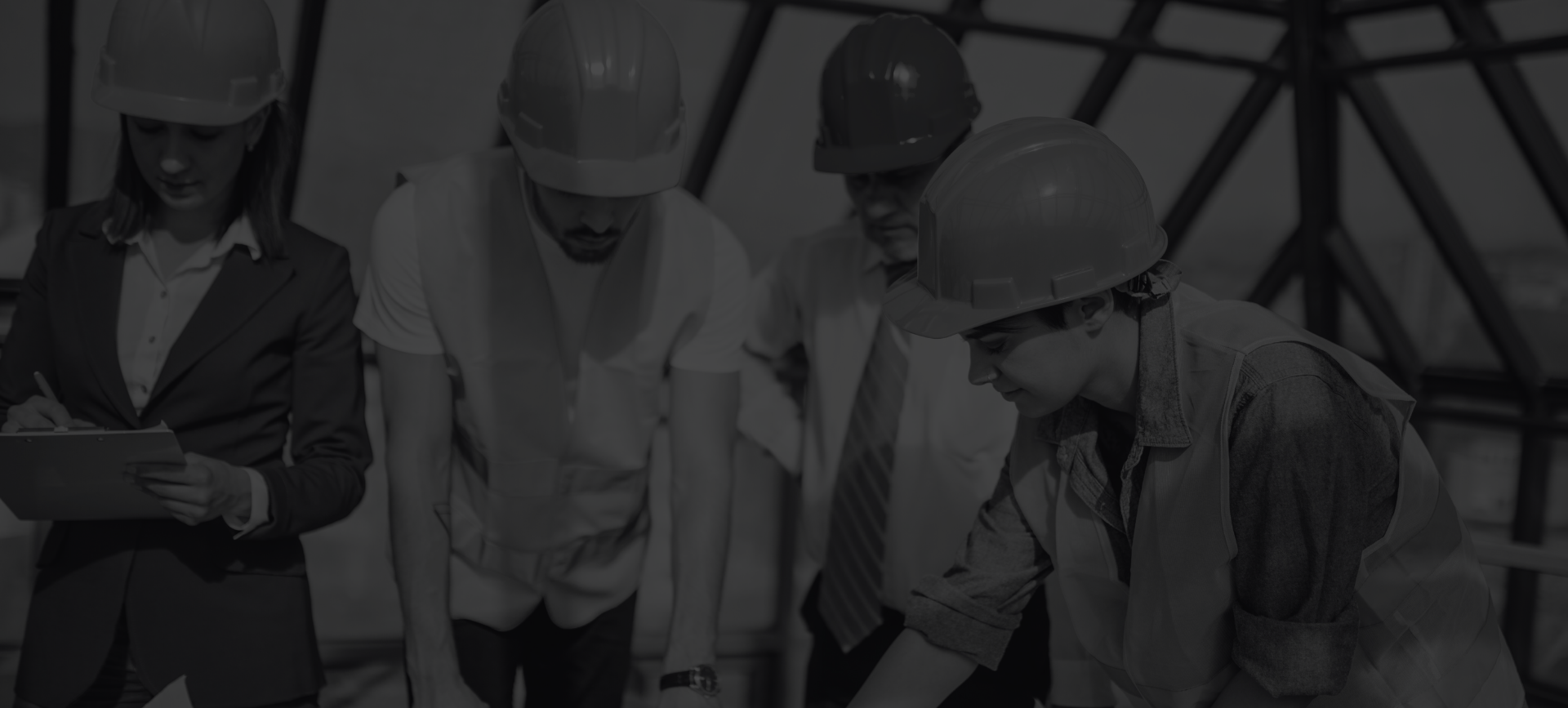 Construction workers in hard hats reviewing plans at a building site