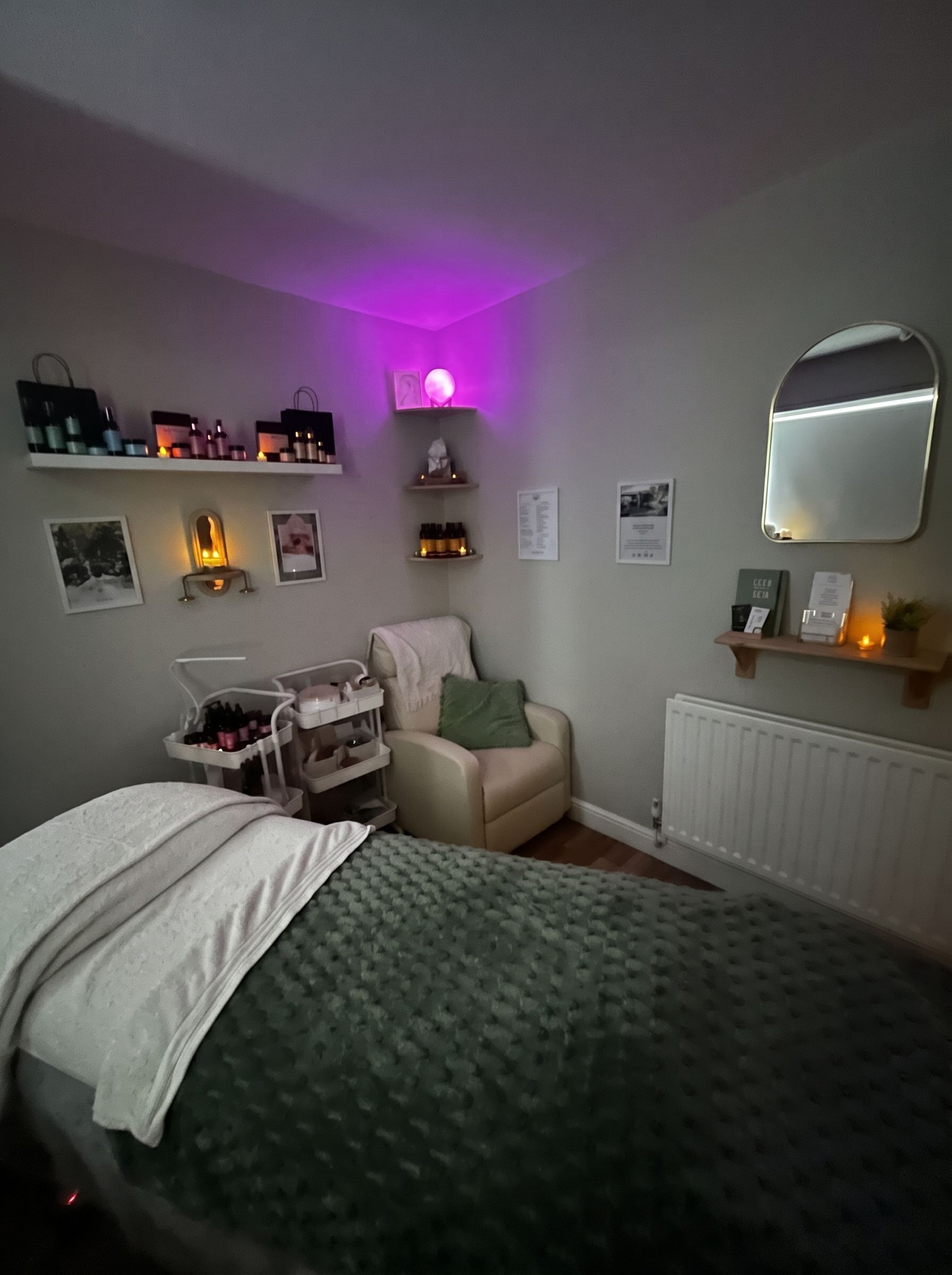 Cozy bedroom with a neatly made bed, soft lamp light, and photos on the windowsill