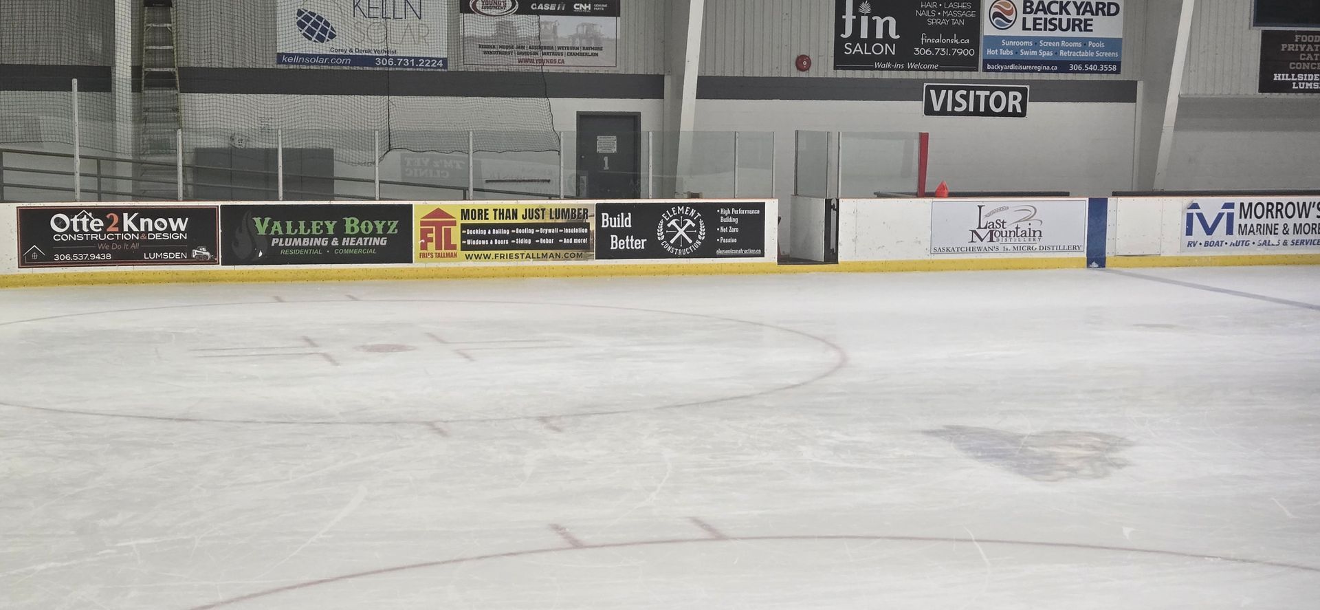 An empty ice rink with a sign that says visit