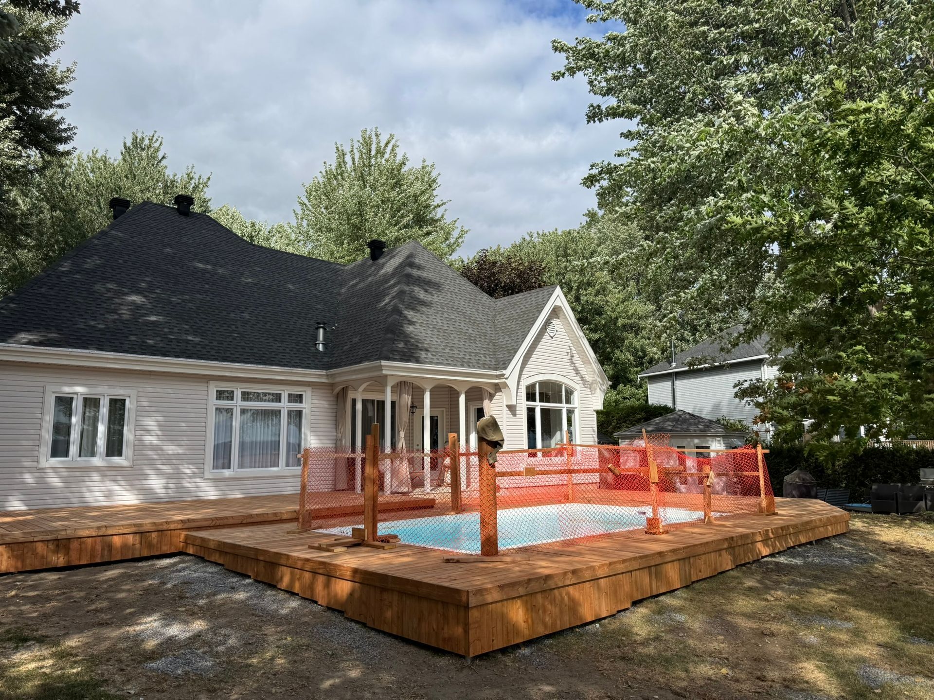 Maison en chantier entour&eacute;e d'une cl&ocirc;ture de s&eacute;curit&eacute; orange