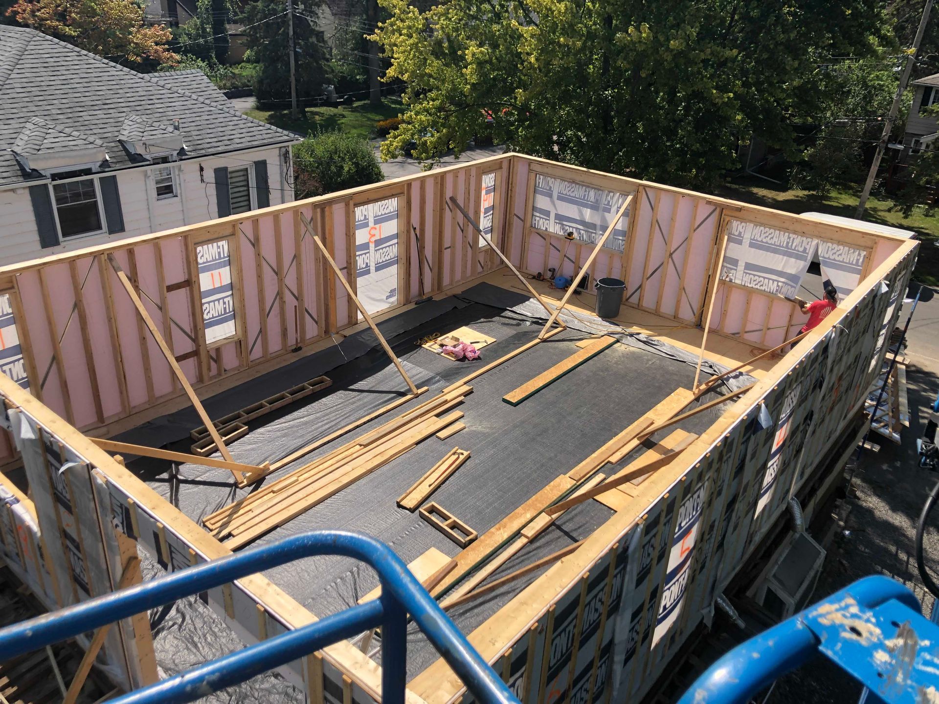 Construction d'un bâtiment : murs à ossature bois avec fenêtres, isolation et toiture, vue de dessus.