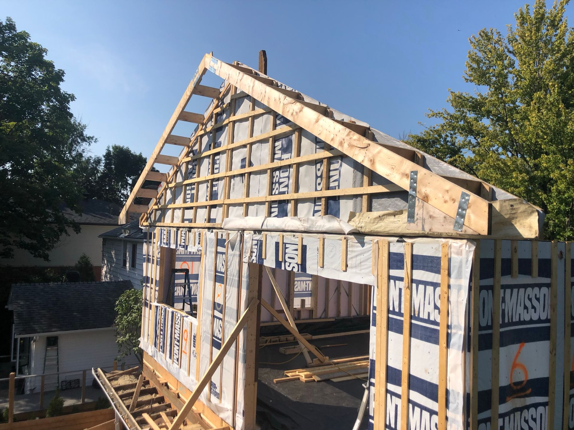 Structure à ossature bois d'une maison en construction, avec poutres et bardage apparents.