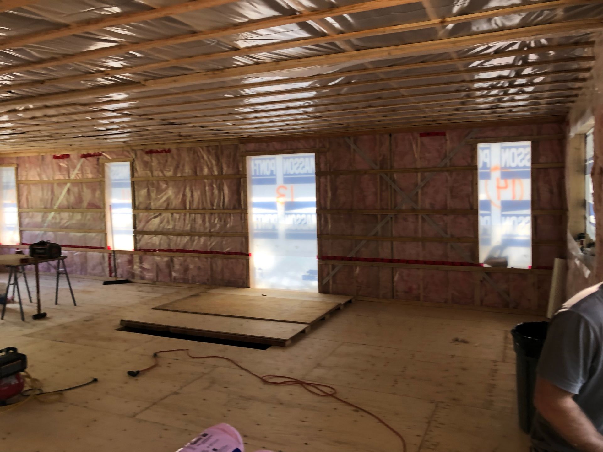 Intérieur d'un bâtiment en construction, murs et plafond isolés avec de la fibre de verre rose.