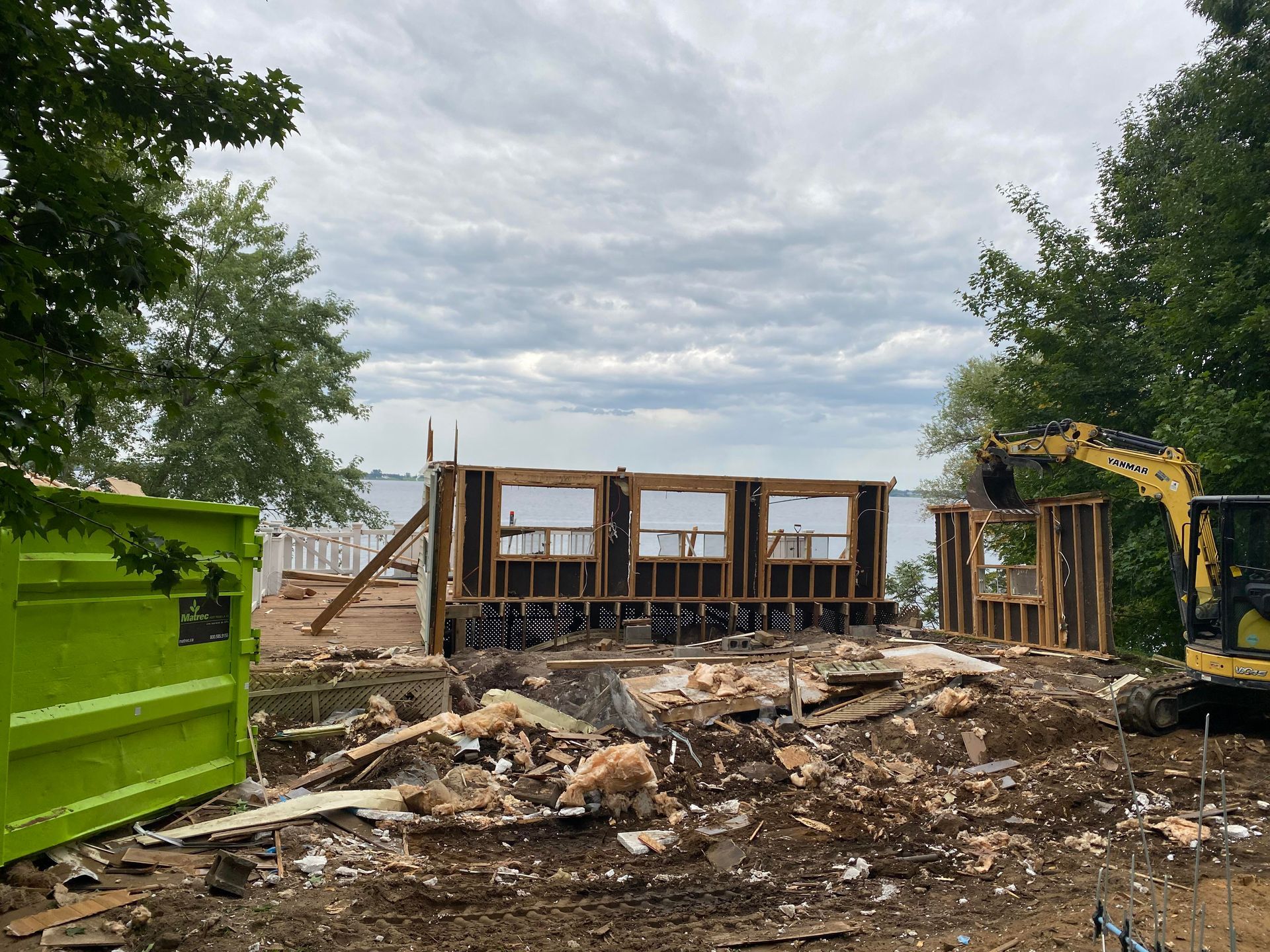 Chantier de construction avec une structure de bâtiment partiellement démolie donnant sur l'eau.