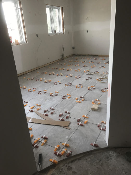 Pièce avec pose de carrelage neuf, entretoises entre les carreaux.
