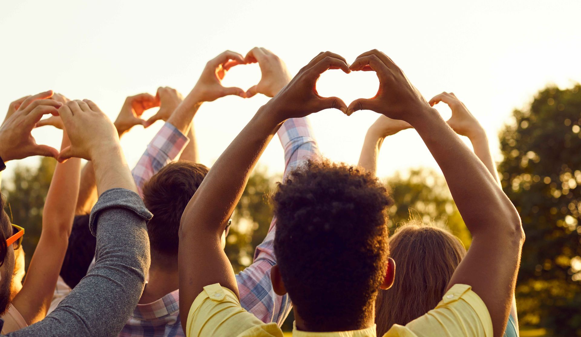 a group of people are making a heart shape with their hands