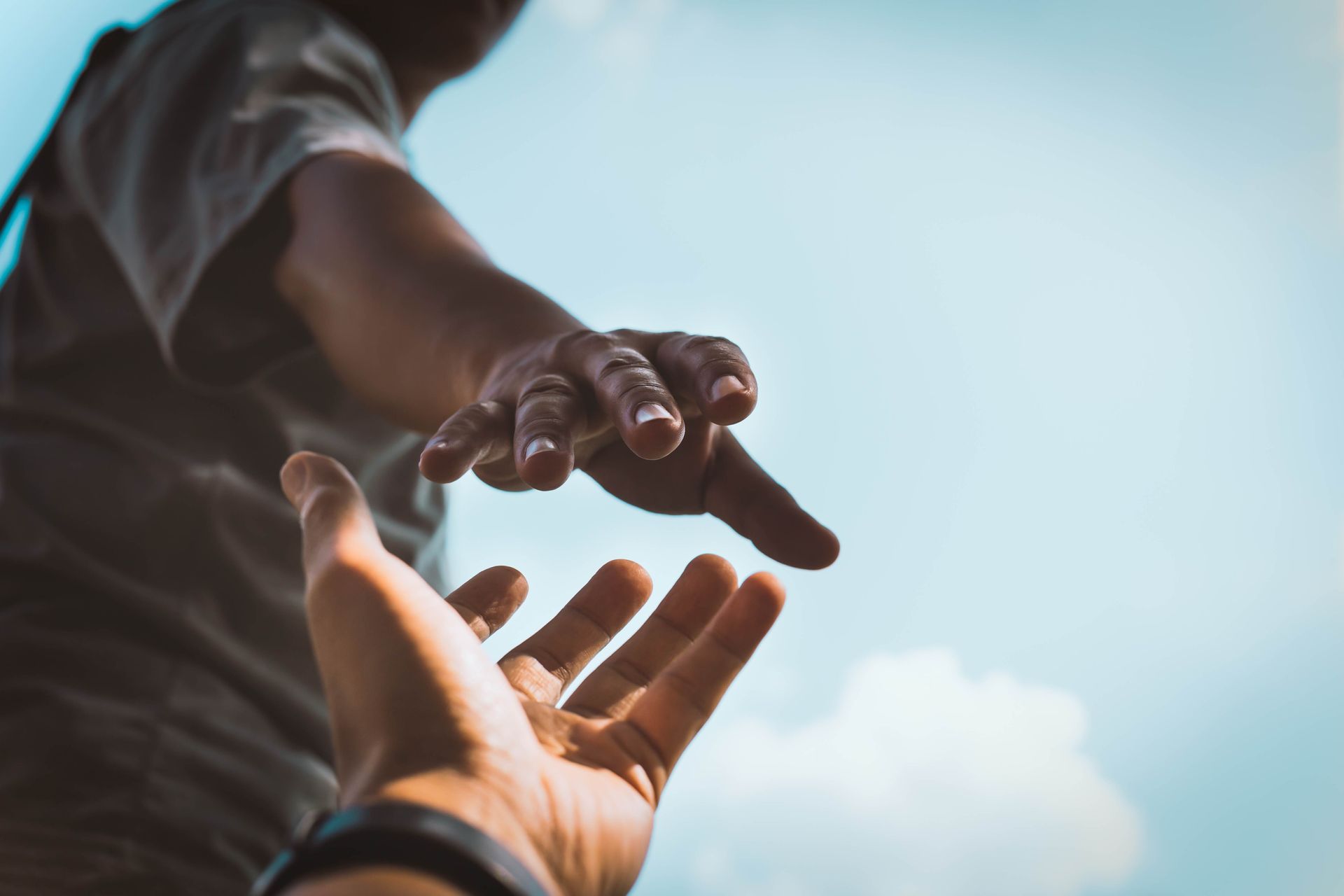 a person is reaching out their hand to help another person