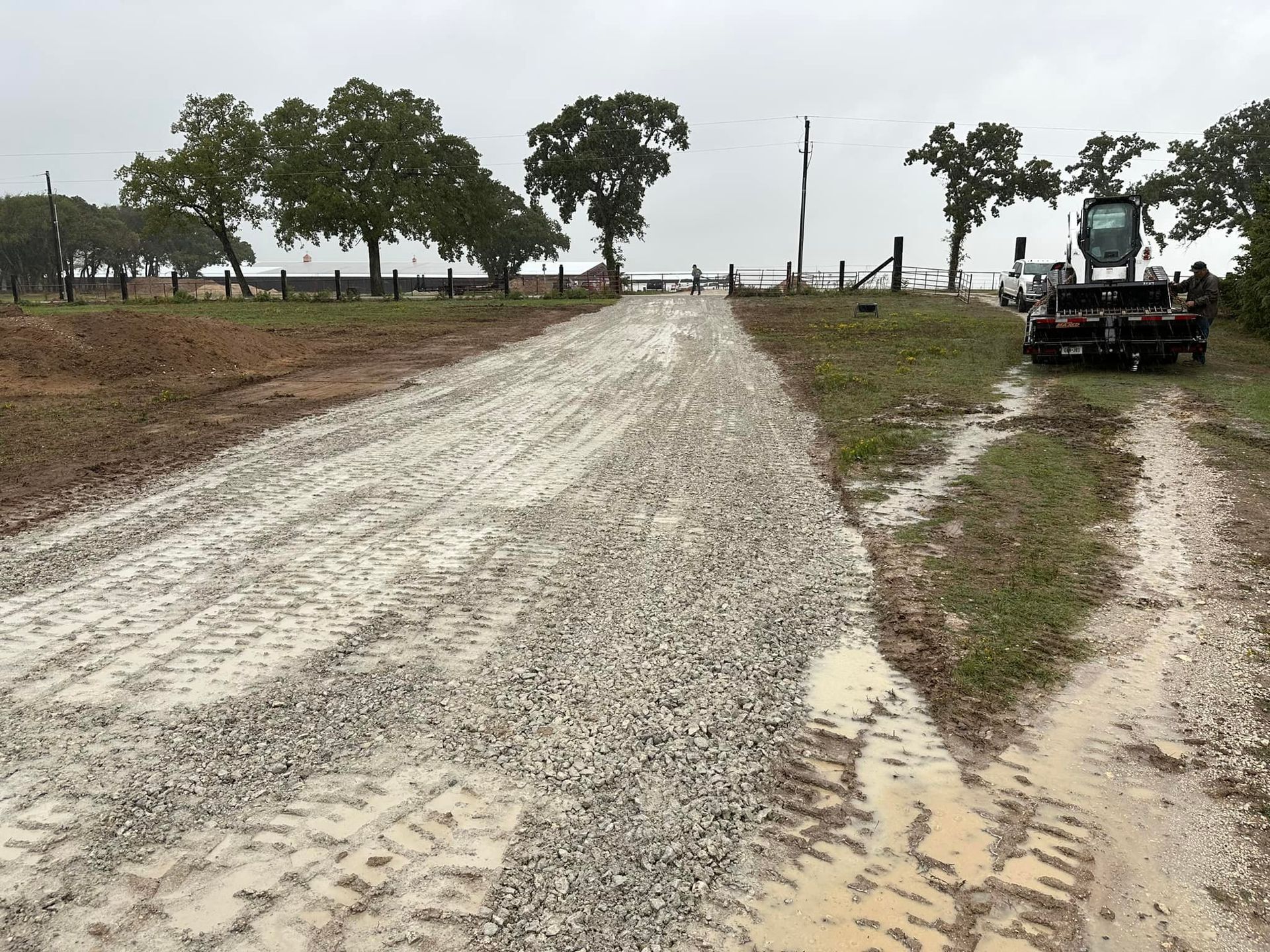 A dirt road with a truck on the side of it.