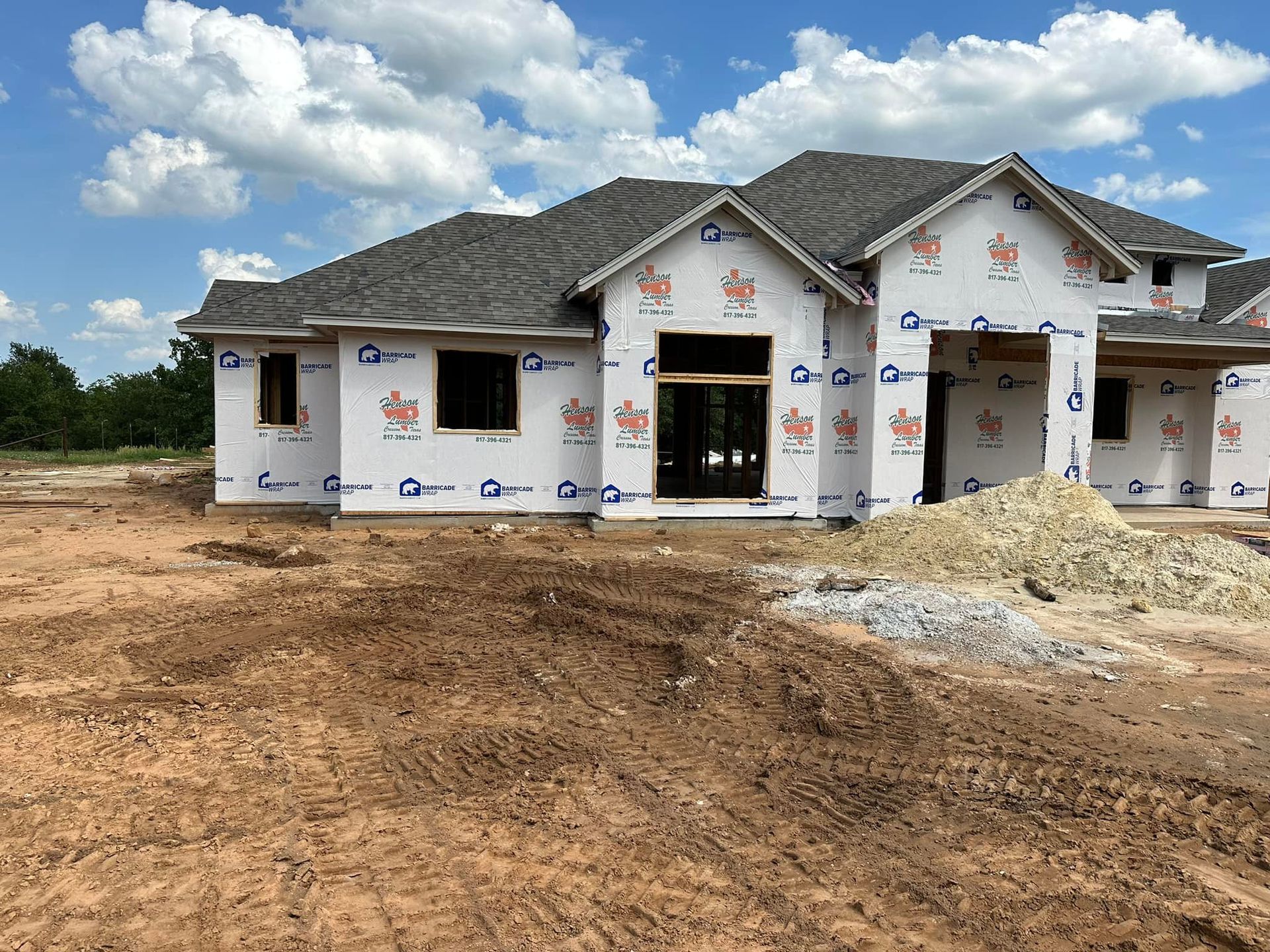 A house is being built in the middle of a dirt field.
