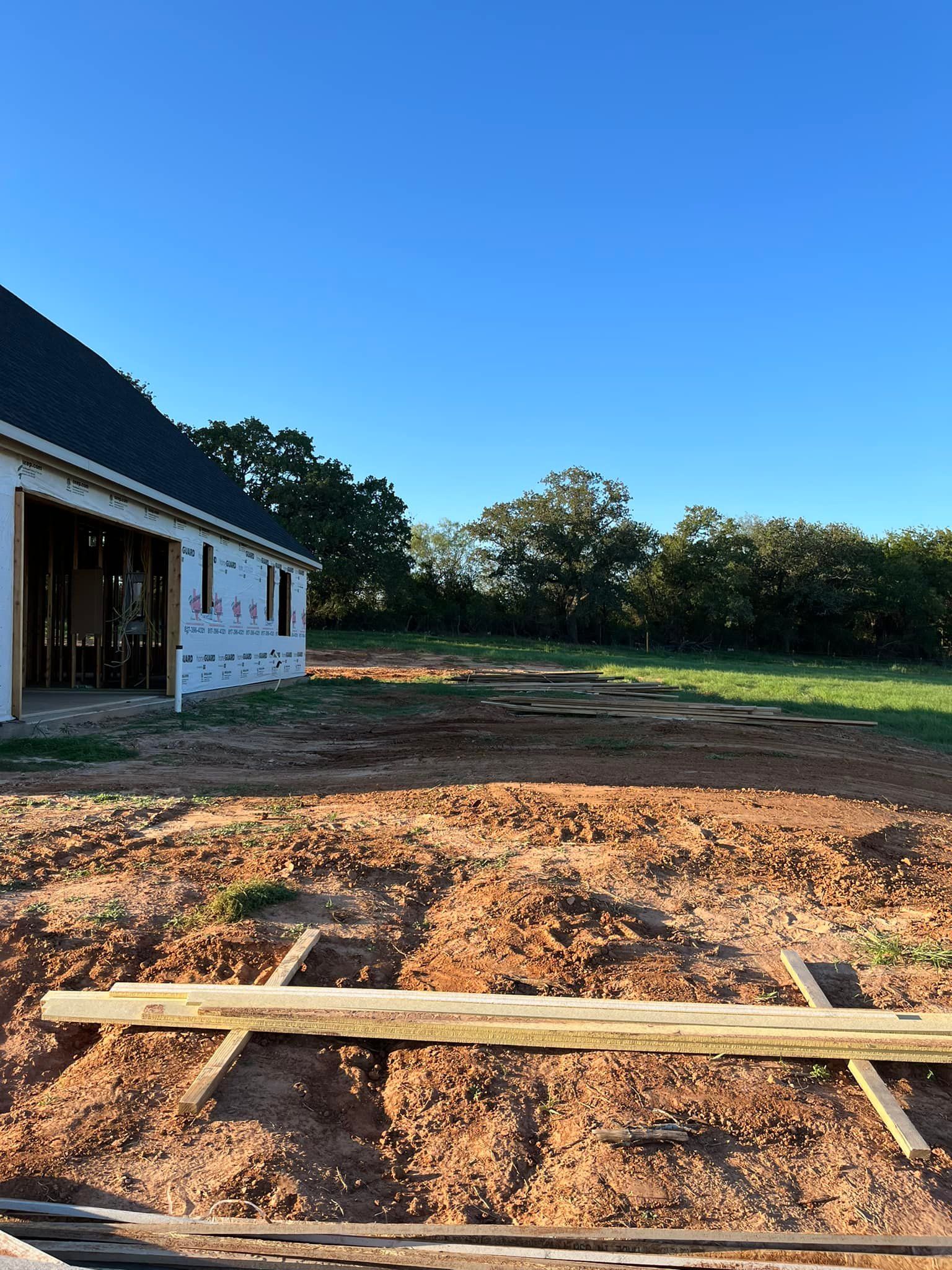 A house is being built in the middle of a dirt field.