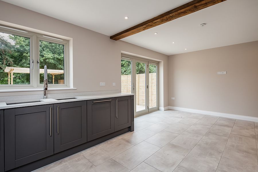 Gray kitchen with cabinets, window, and French doors leading outside.