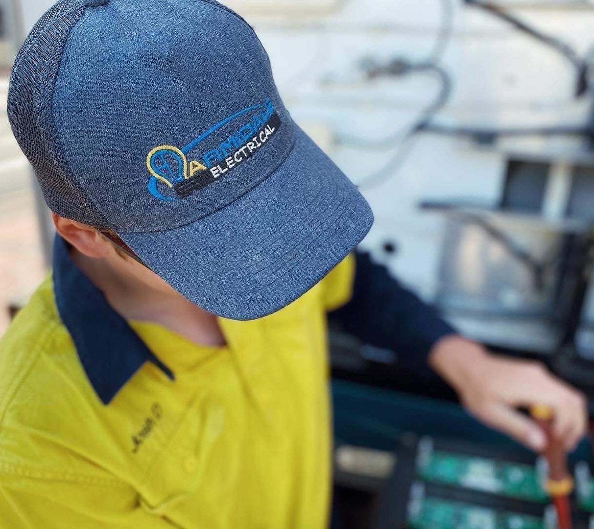 Electrician Wearing Armidale Electrical Cap — Electrical Contractors in Armidale, NSW