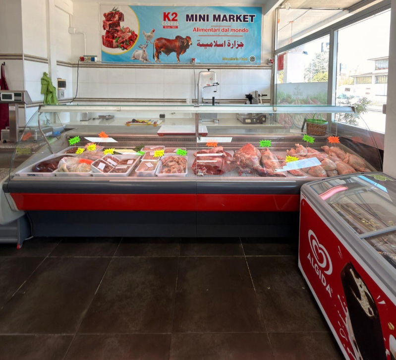 Banco macelleria in un minimarket con carni confezionate sotto l'insegna K2 Mini Market.