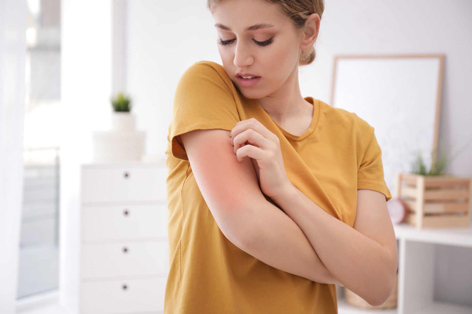 A woman is scratching her arm in a living room