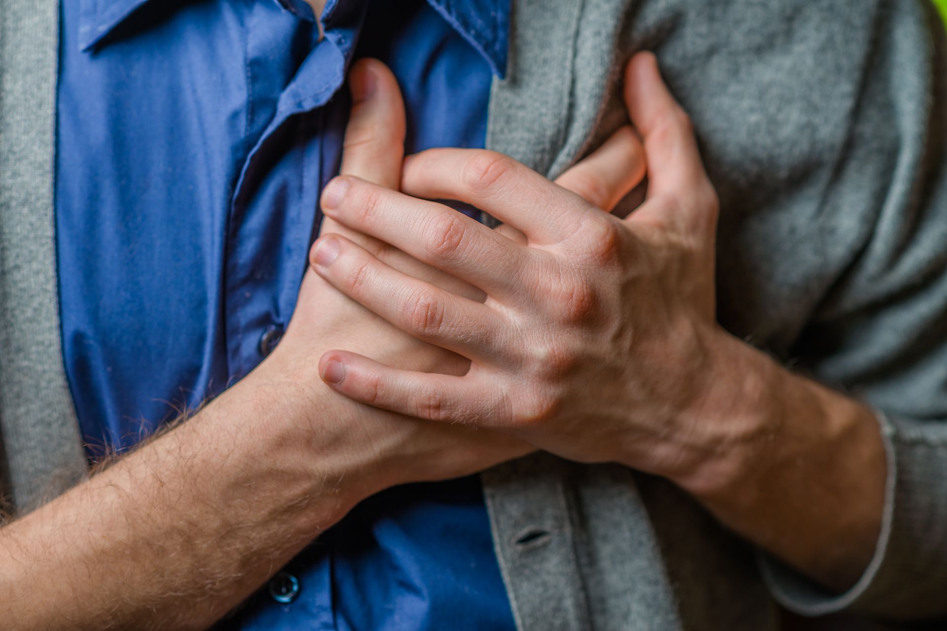A man is holding his chest in pain because he has a heart attack