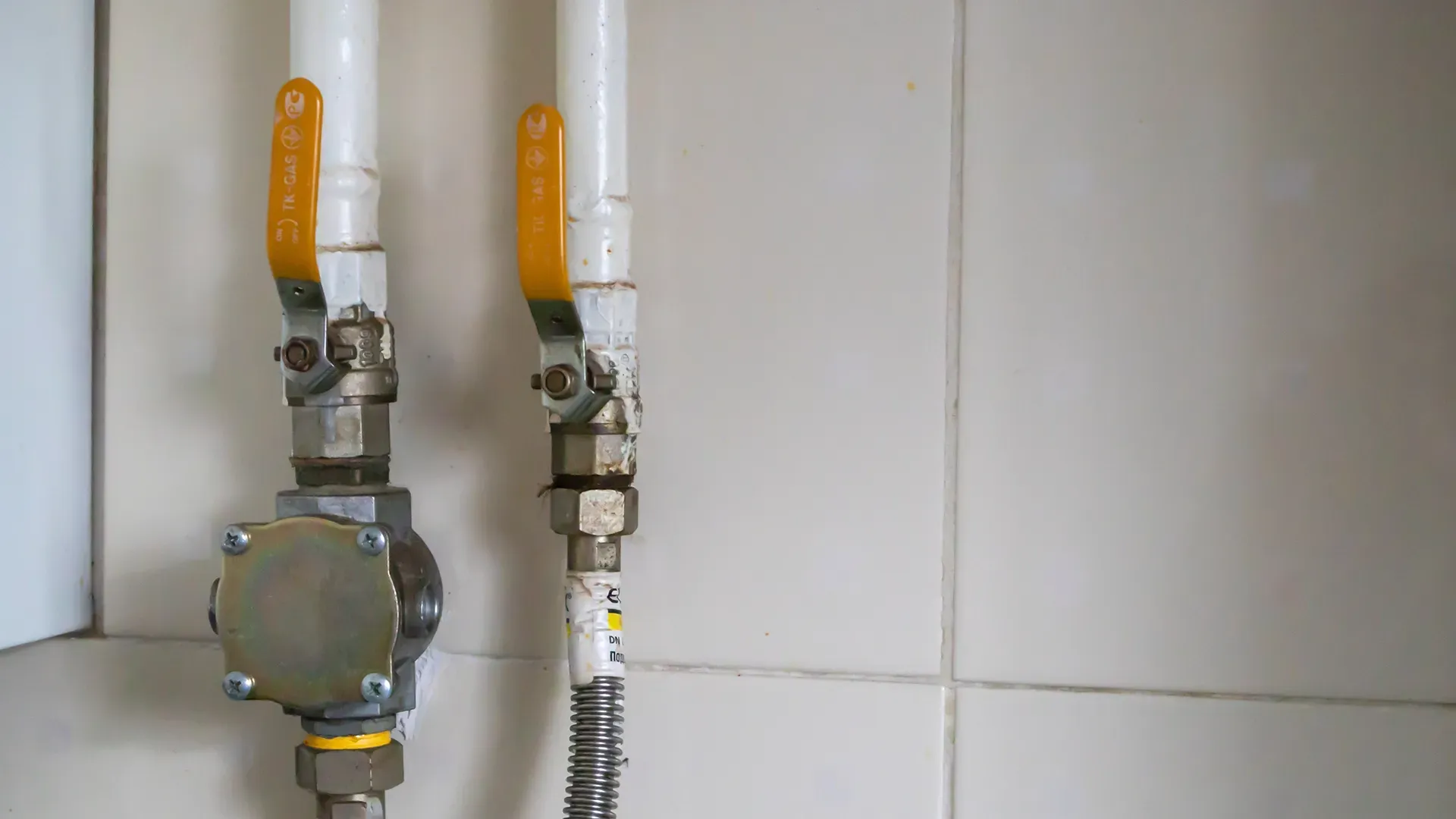 a close up of two gas pipes on a wall .