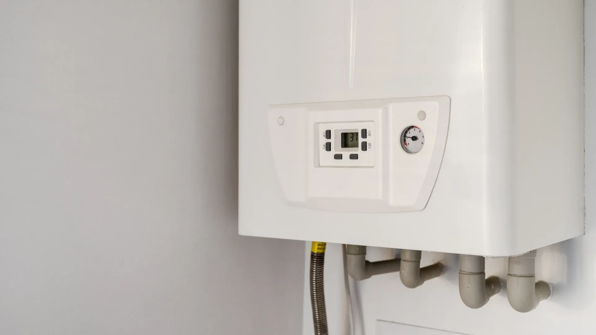 A white insta hot water heater is hanging on a white wall.