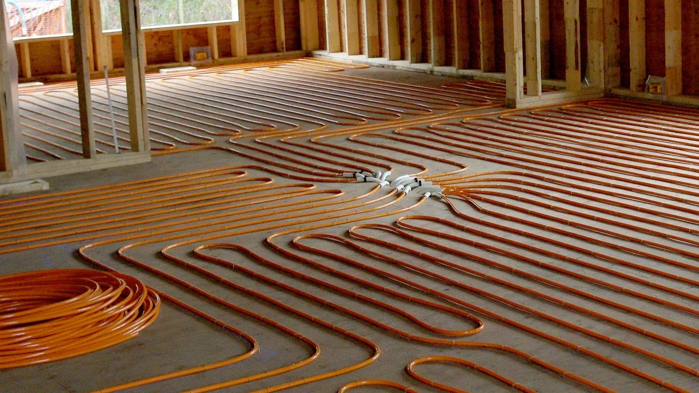 A room with a lot of pipes on the floor for purposes of creating radiant heated floors