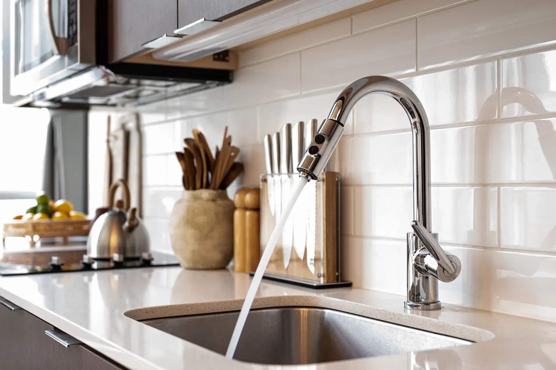 A kitchen sink with water running from the faucet.