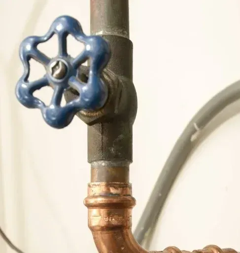 A copper pipe with a blue valve attached to it