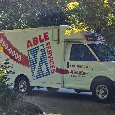 White Able Services van parked on a driveway, with company logo and phone number visible.