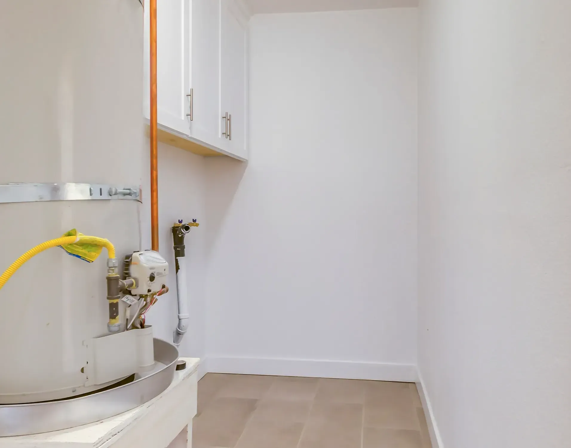 a laundry room with a water heater and a sink .