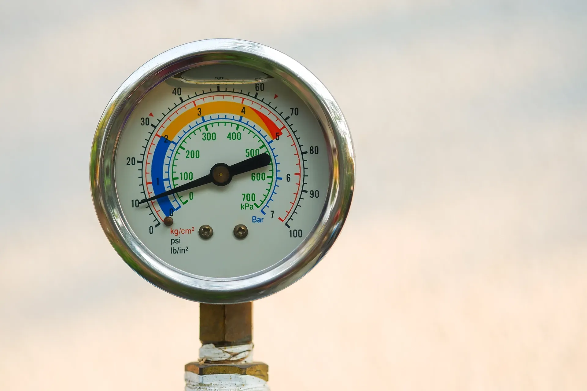 Pressure gauge with a black needle pointing to approximately 300, with a blue, yellow, and red color-coded range.