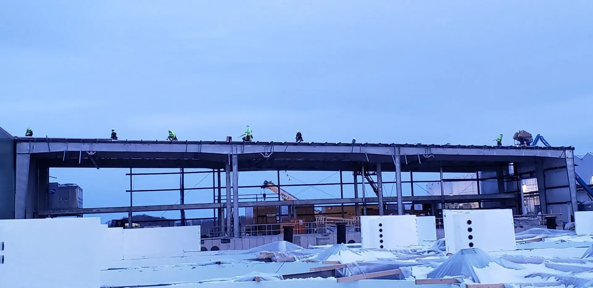Snow-covered industrial conveyor structure in a snowy landscape at dusk