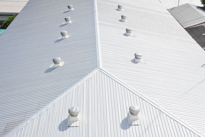 White corrugated roof with several skylights and curved seams, viewed from above