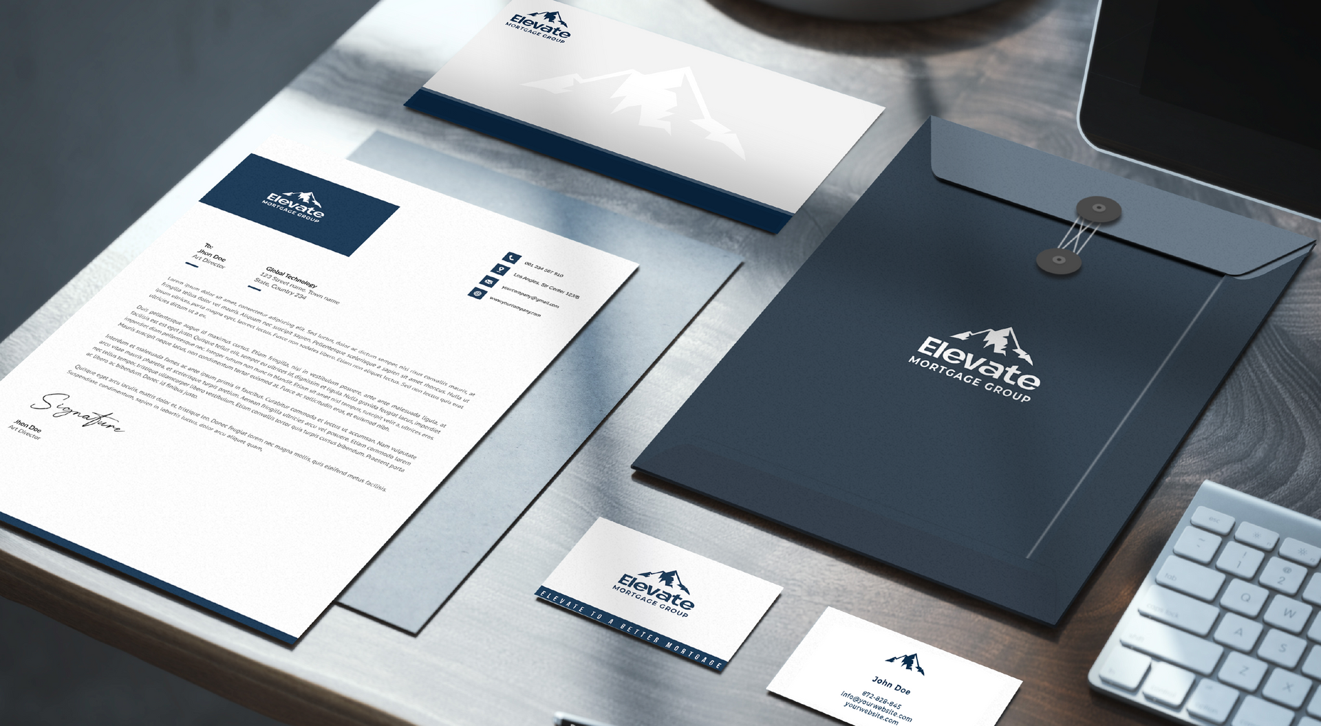 A desk with a letter , envelope , business card , and keyboard.