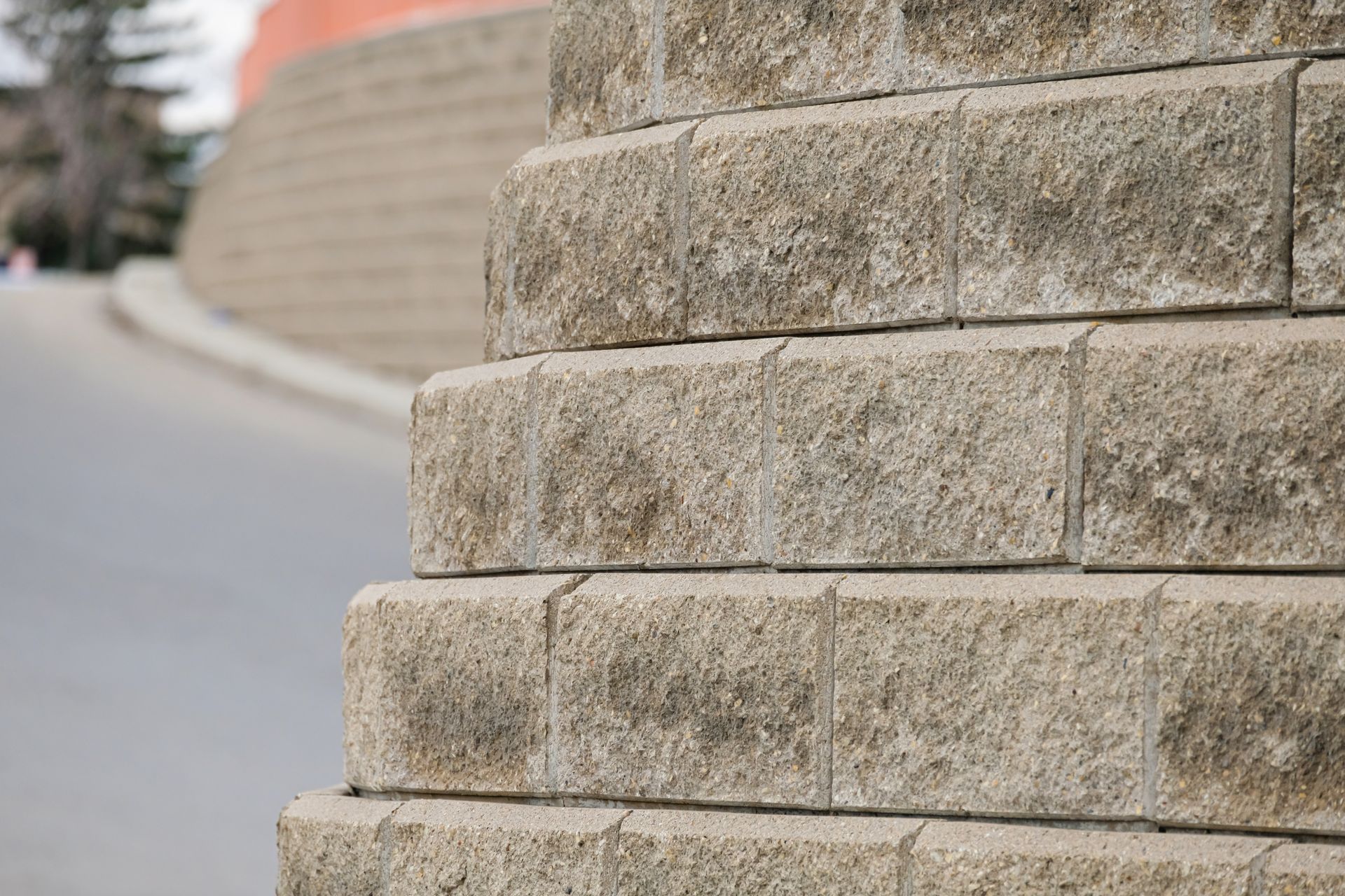 Close-up of a stone wall beside a curved roadside path