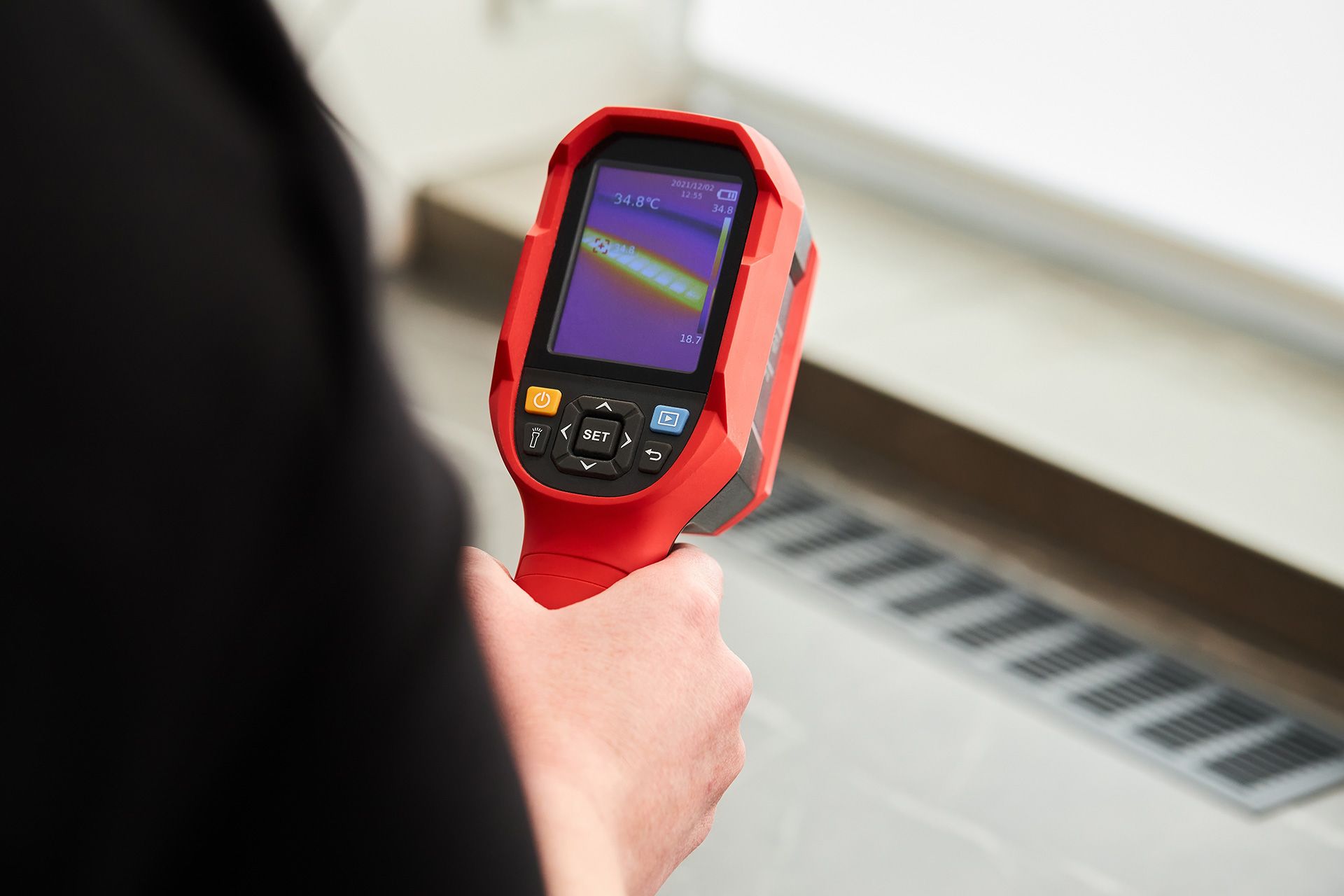 Person holding a red thermal camera for Thermal Inspection